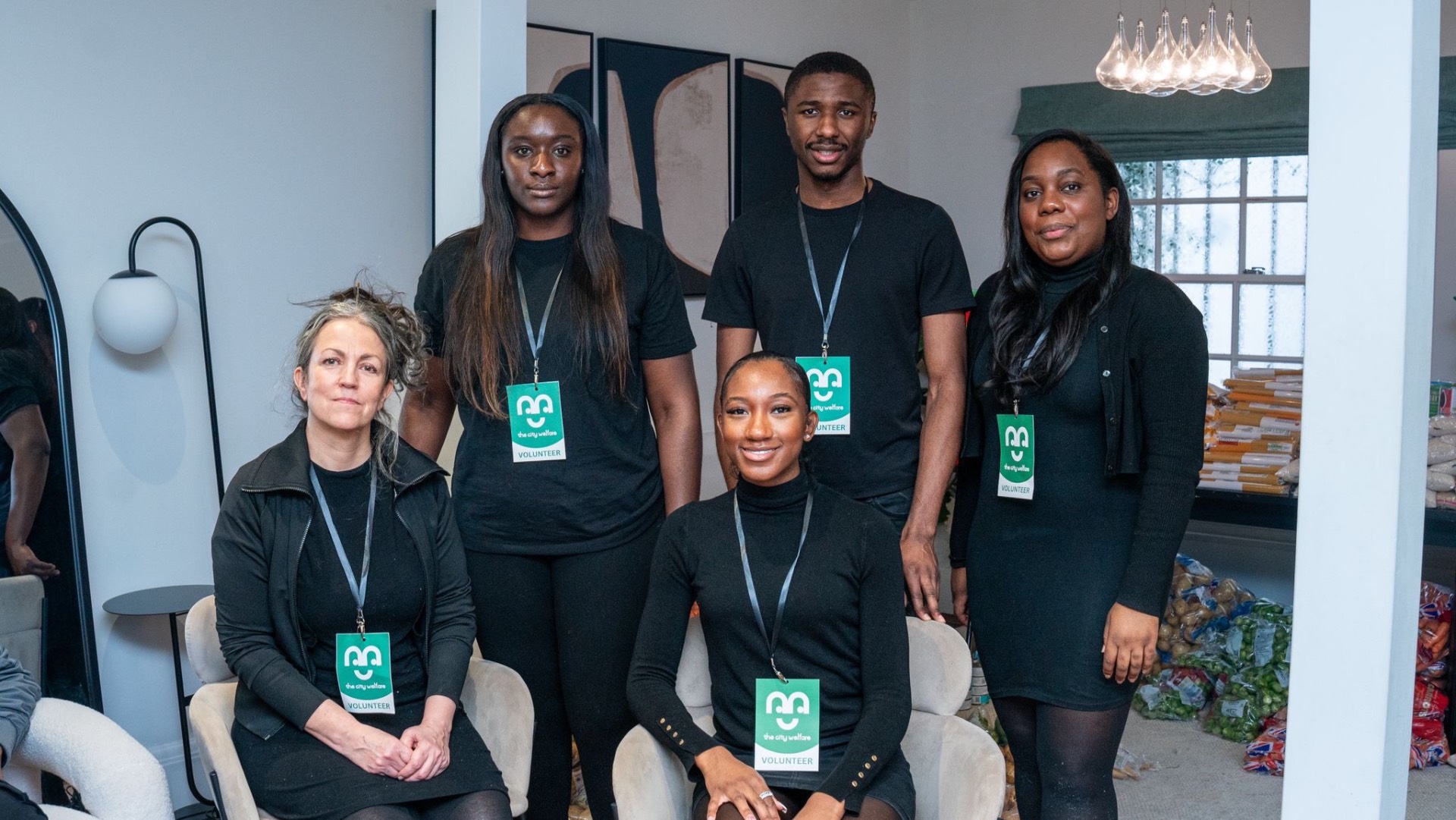 A group of City Welfare volunteers in black uniforms wearing green branded lanyards